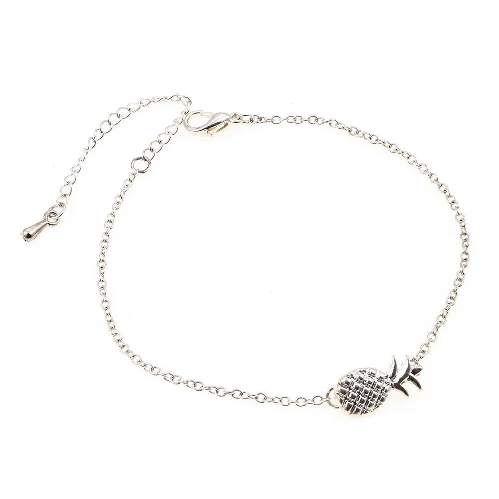Women's alloy bracelet with a pineapple charm in gold or silver tone on a wrist.