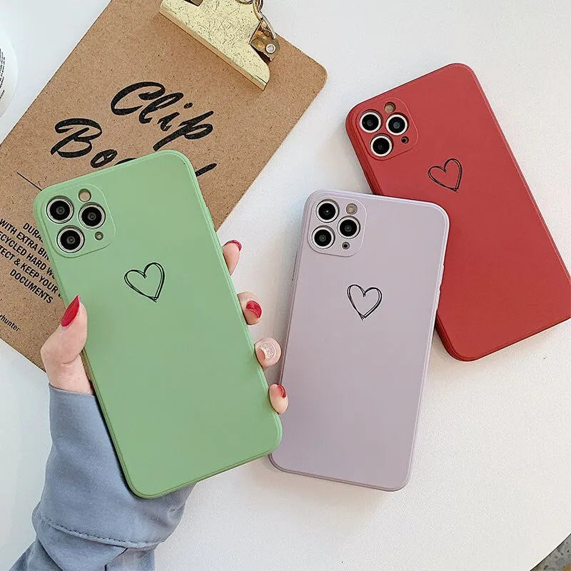Solid colour silicone TPU back cover case for Apple iPhone on a table, showing colour options.