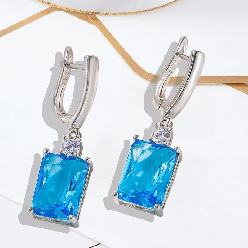 A pair of square geometric earrings with a gold electroplated finish on a copper base.