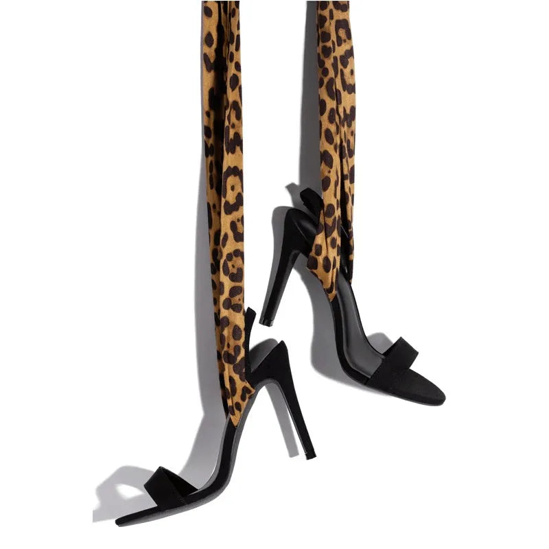Light brown leopard print women's high heel sandals with Roman style cross straps and a thin high heel.