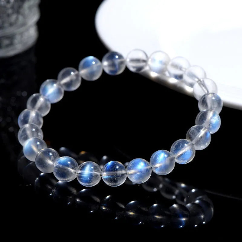Natural blue moonlight cream body crystal bracelet on wrist, showing single strand of polished beads.