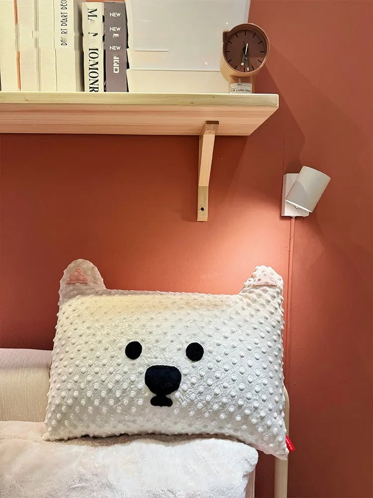 Grey schnauzer and white West Highland puppy decorative throw pillows on a sofa.