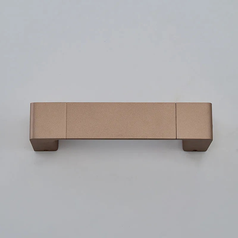 Modern minimalist wall lamp with aluminium shade in gold finish against a white wall
