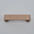 Modern minimalist wall lamp with aluminium shade in gold finish against a white wall