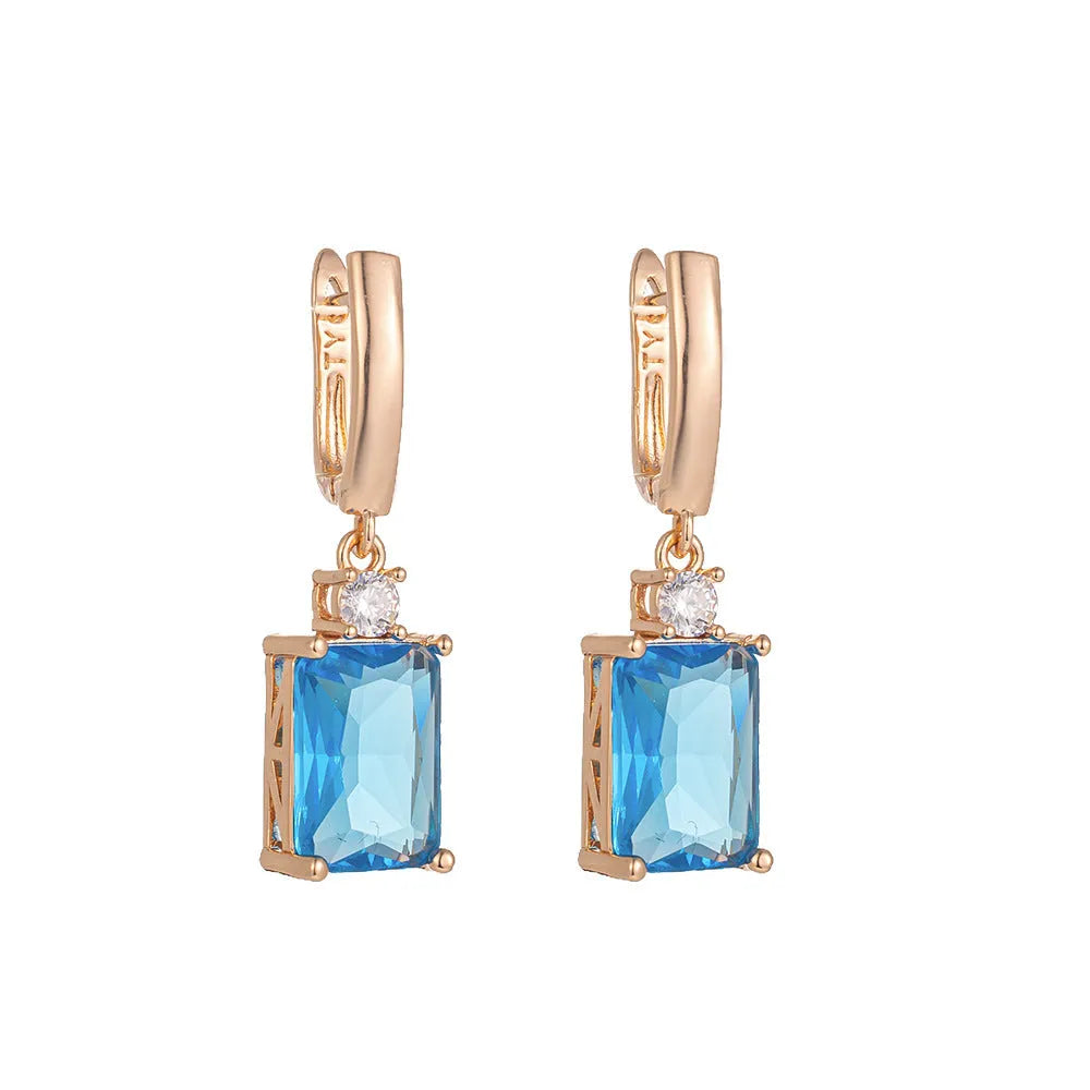 A pair of square geometric earrings with a gold electroplated finish on a copper base.