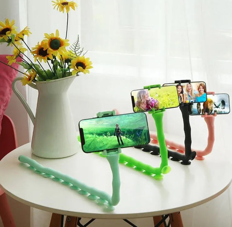 Black flexible phone holder with suction cup mounted to wall showing 62cm adjustable arm holding mobile phone