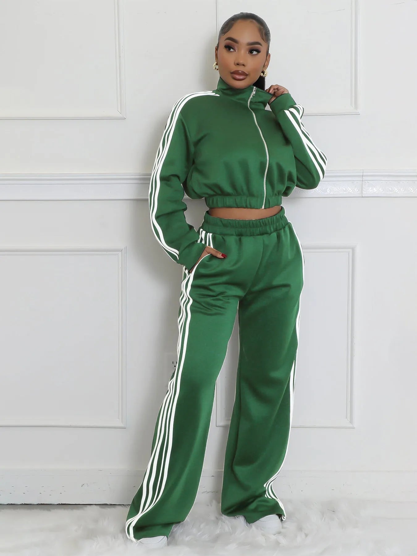 Man wearing a grey striped zip-up sweater and matching trousers from a two-piece polyester streetwear set.