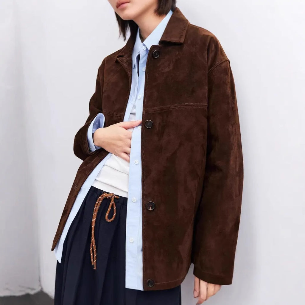 Yellow brown retro cashmere coat with Peter Pan collar, leather stitching, and a belt on a hanger.