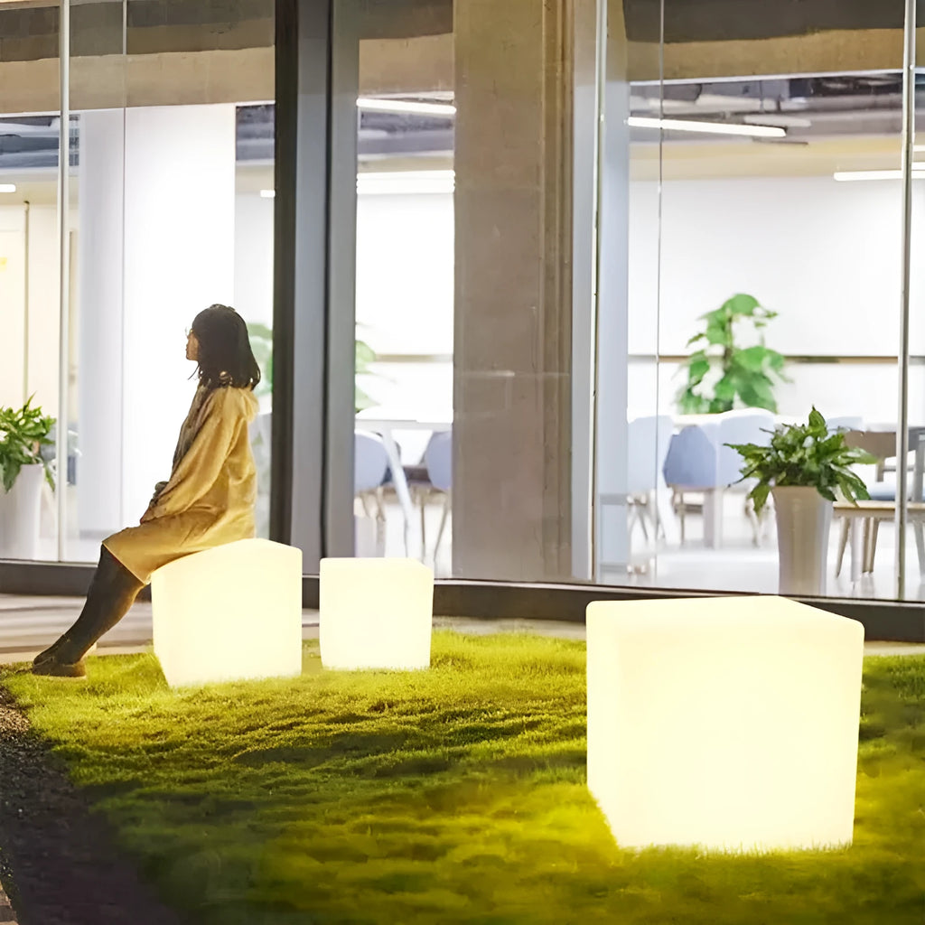 Square LED cube stool light in garden setting showing modern design with lighting