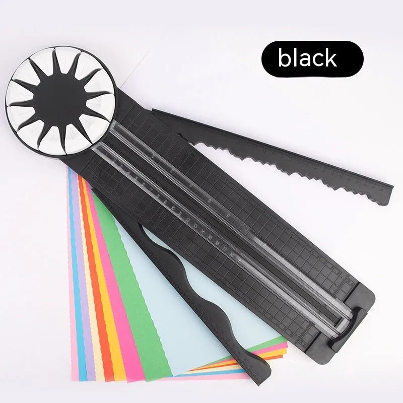 Pink and black 12-in-1 multifunctional plastic paper cutter with dotted guides on a cutting mat.