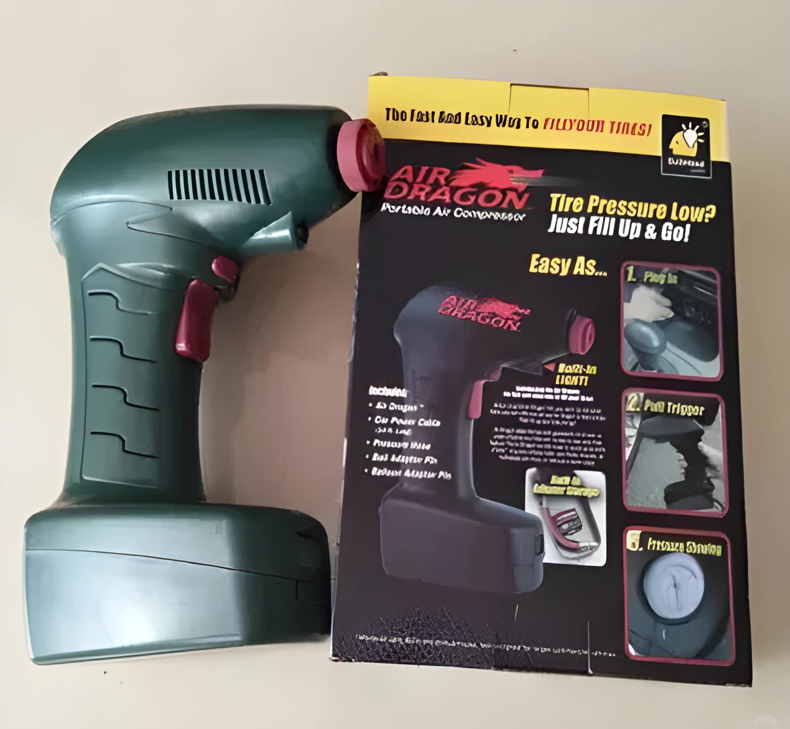 Portable 12V car tyre electric pump with digital gauge and hose on a grey background.