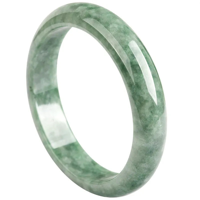 Dark pea green jade bracelet on a wrist, showing its simple band style and natural colour.