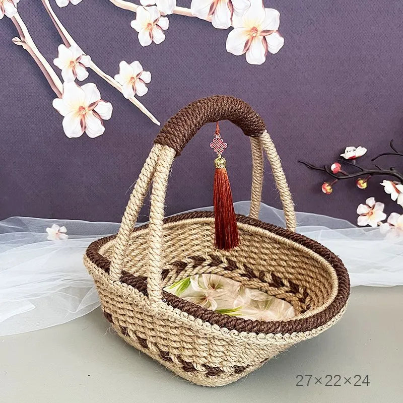 Coffee brown hand-woven straw basket with hemp rope handle, shown next to a small plant for scale.