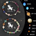 Two natural stone beaded bracelets with carved zodiac animal designs on a wooden surface.