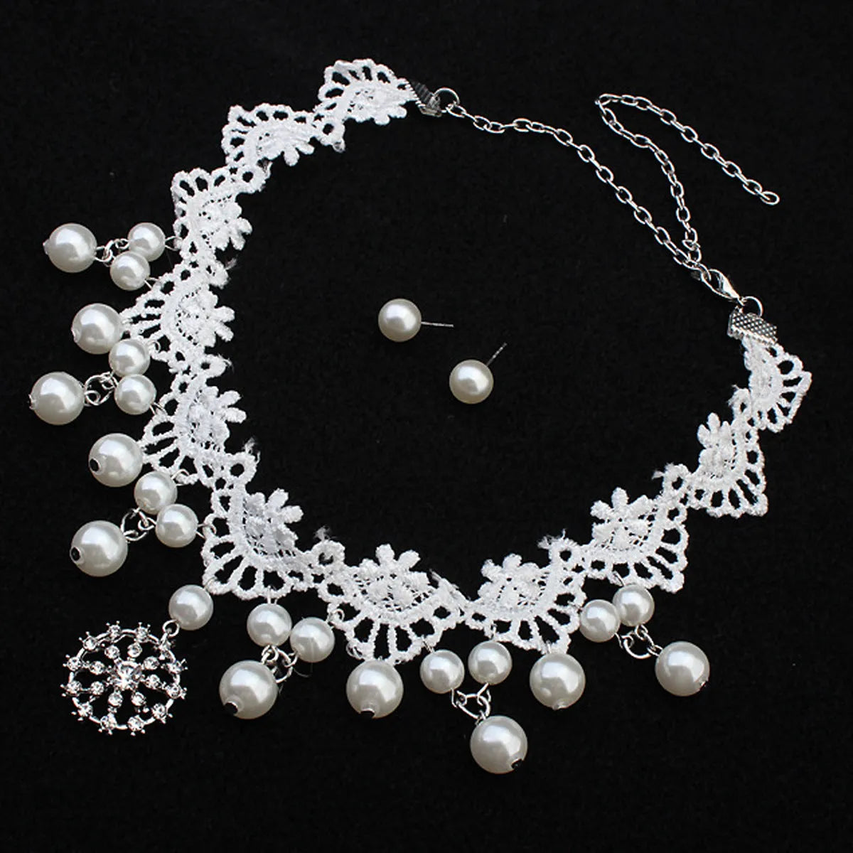Three-piece white pearl jewellery set with necklace, earrings, and bracelet on display