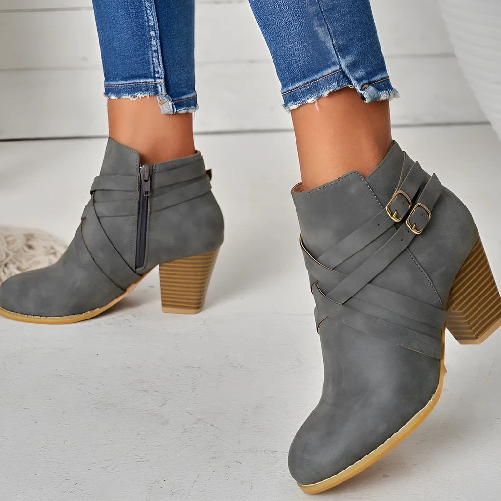 Women's short ankle boot with 7cm heel, side zipper, and belt buckle detail in grey.