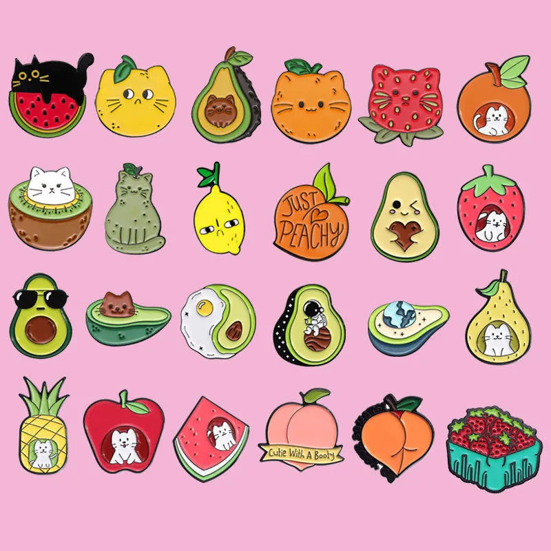 Colourful cartoon fruit design metal letter brooch on a fabric background.