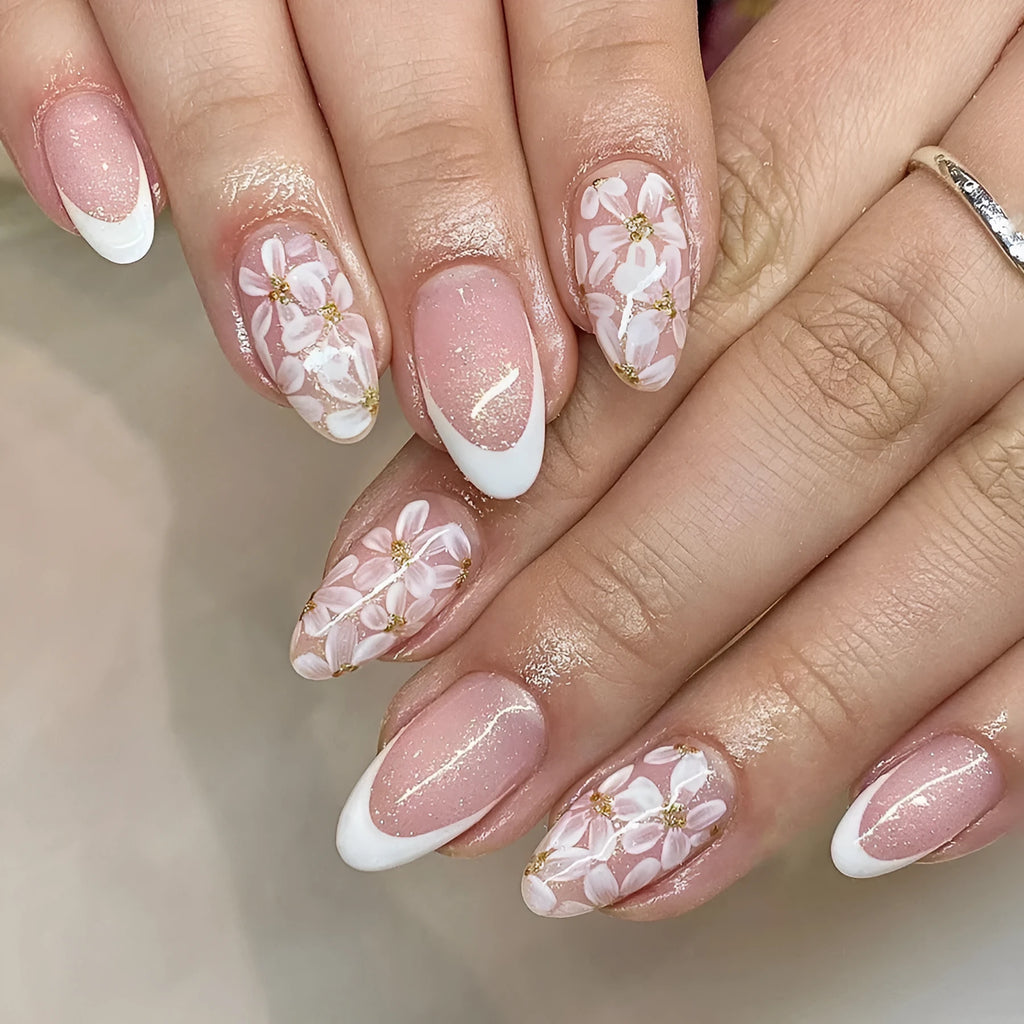 Short glossy almond-shaped press-on nails with French style, floral designs and glitter accents in C625 colour