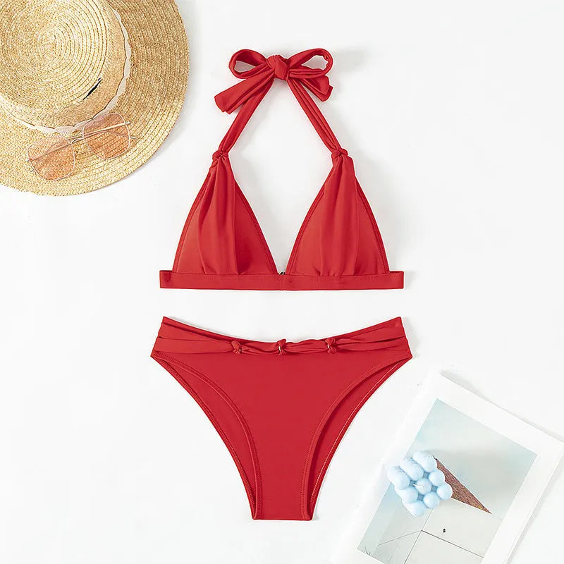 Red women's bikini set with lace-up halterneck top and matching split shorts on a mannequin.