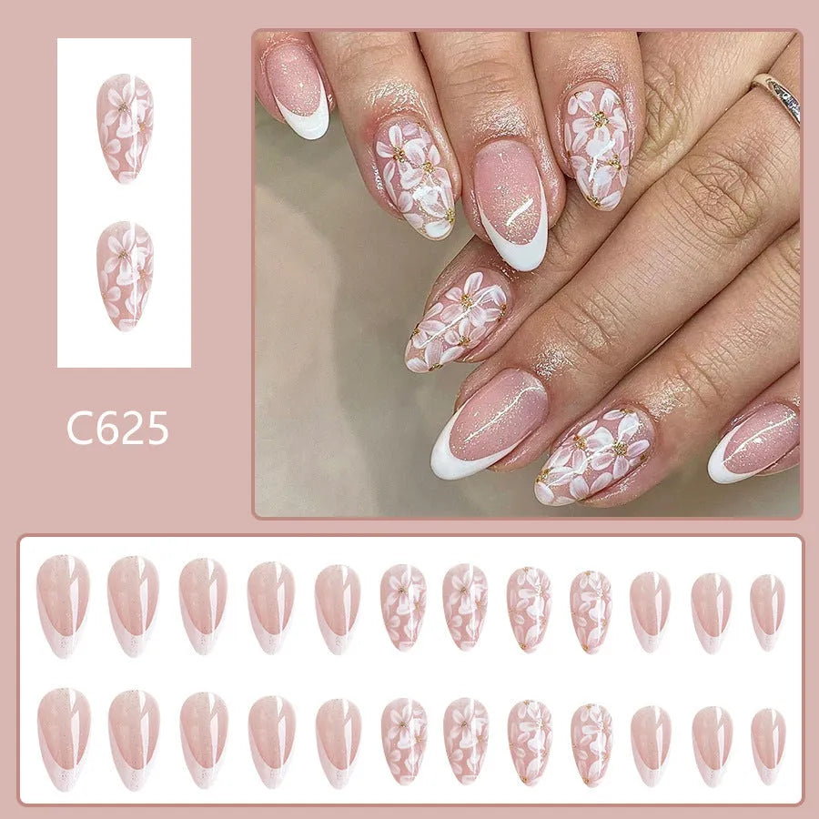 Short glossy almond-shaped press-on nails with French style, floral designs and glitter accents in C625 colour