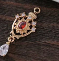 Small gold electroplated copper pendant with hollow crown water drop design and micro-inlaid zircon stones.