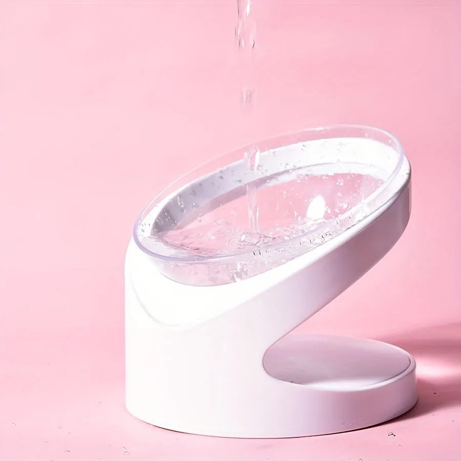 White elevated tilted plastic cat food bowl on a flat surface