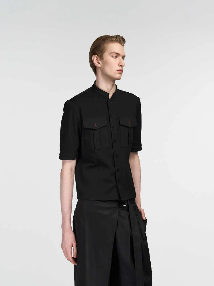 Handmade black half-sleeve hunting shirt with shirt collar on a hanger.