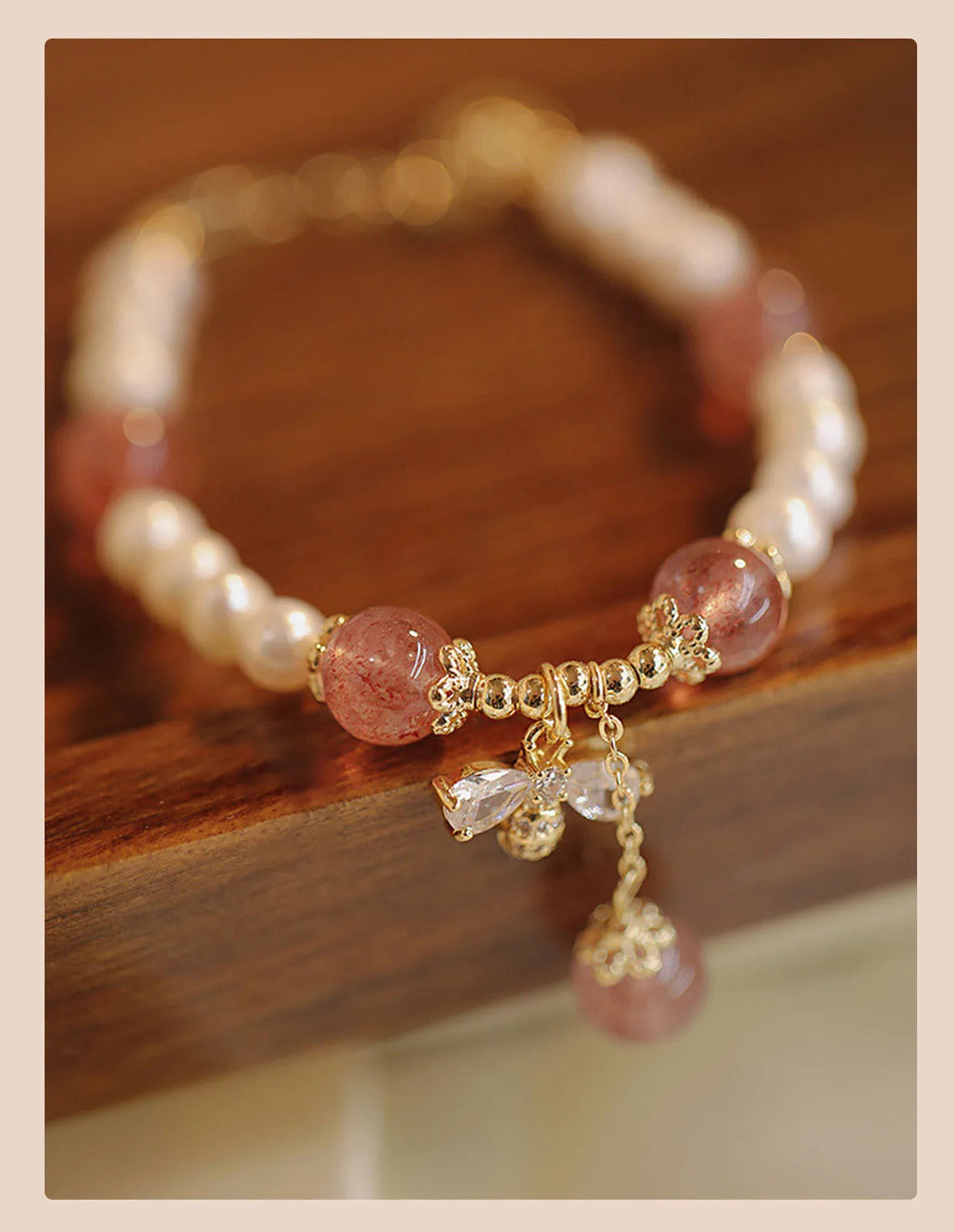 Women's hand-made strawberry quartz crystal bracelet with stringed pearls and bow detail