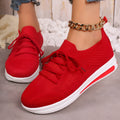 Women's low-top black fly-knit sneakers with round toe and white lace-up front.