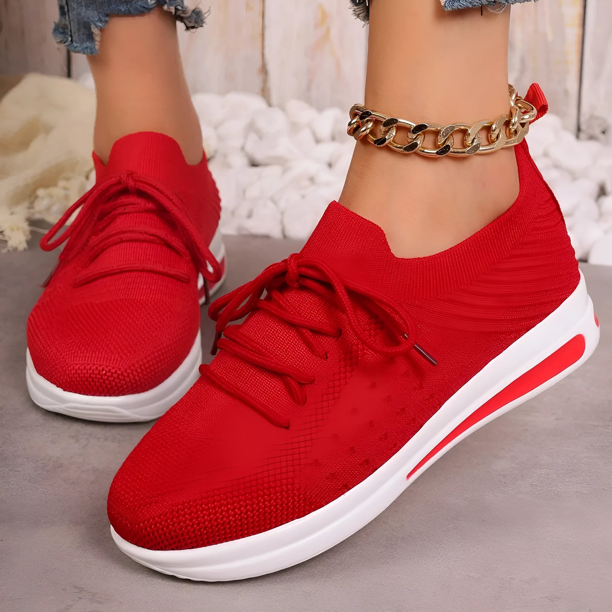 Women's low-top black fly-knit sneakers with round toe and white lace-up front.