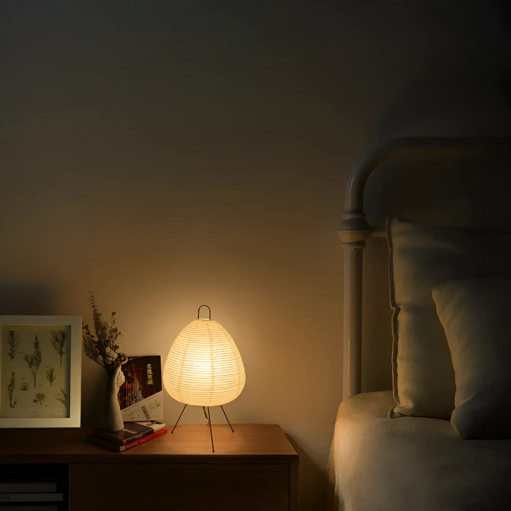 Japanese style table lamp with handmade paper shade and aluminium base on a wooden surface.