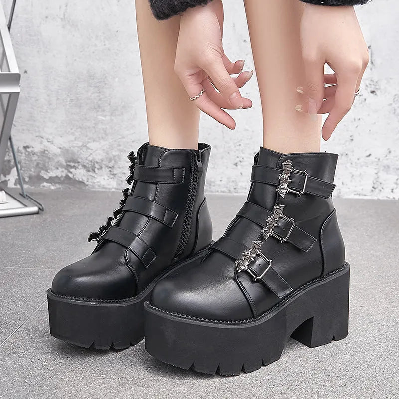 Black women's punk boots with bat buckle, side zip, thick heel, and round toe.