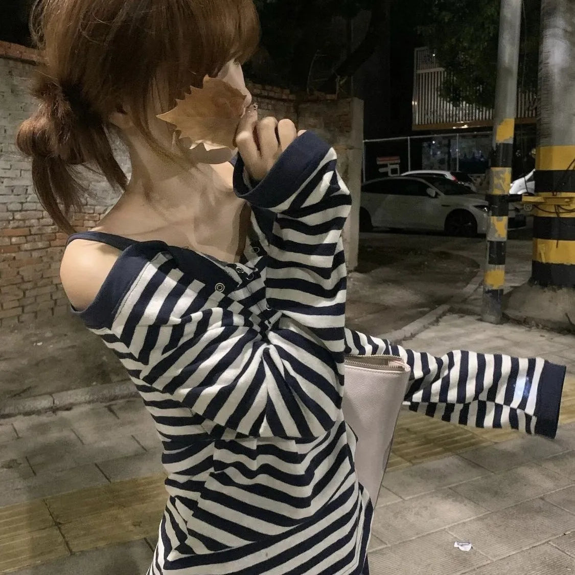 Dark blue women's long-sleeved t-shirt with an oversized fit, showing stripe and embroidery detail on the front.