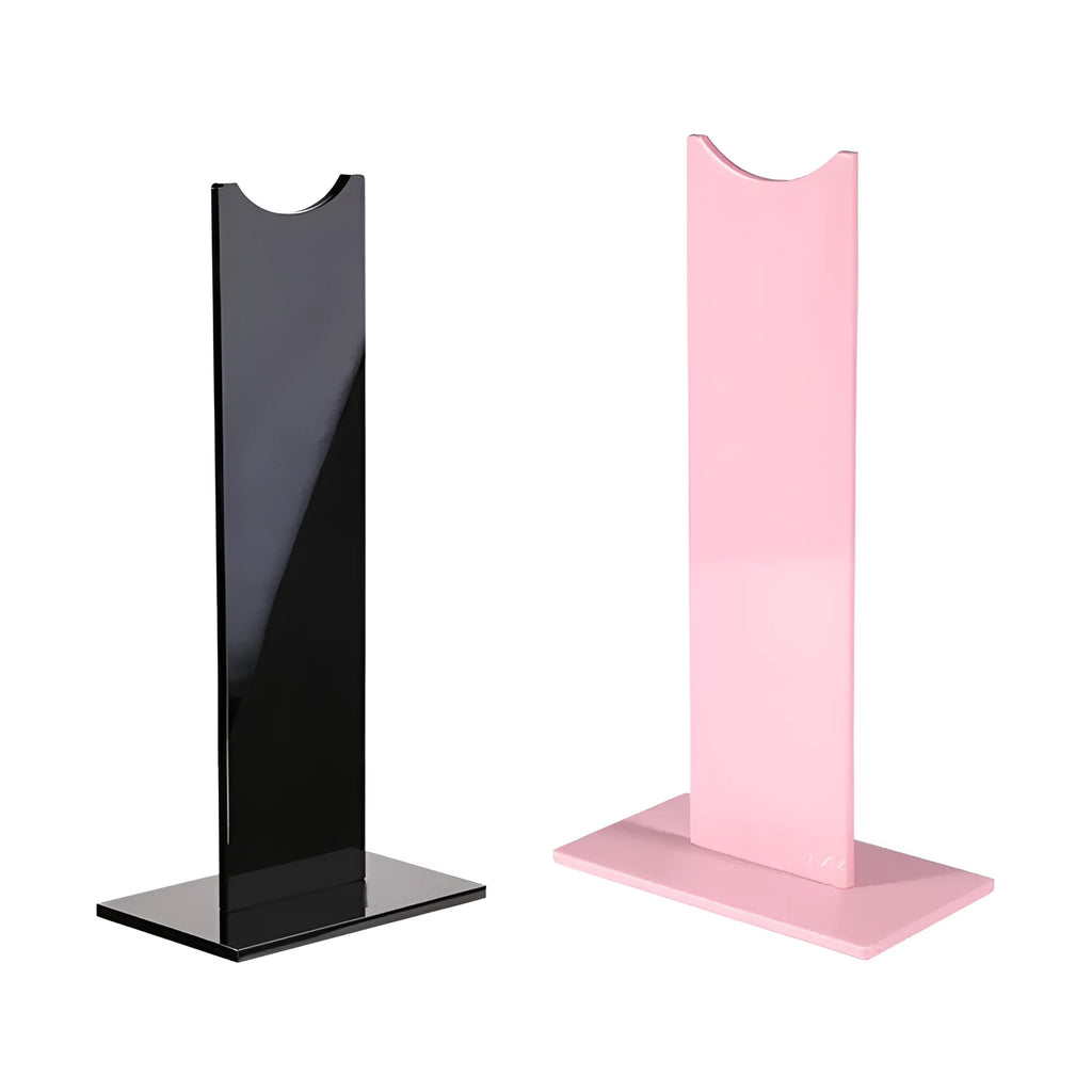 Pink and black foldable head-mounted headset stand with a non-slip silicone base on a desk.