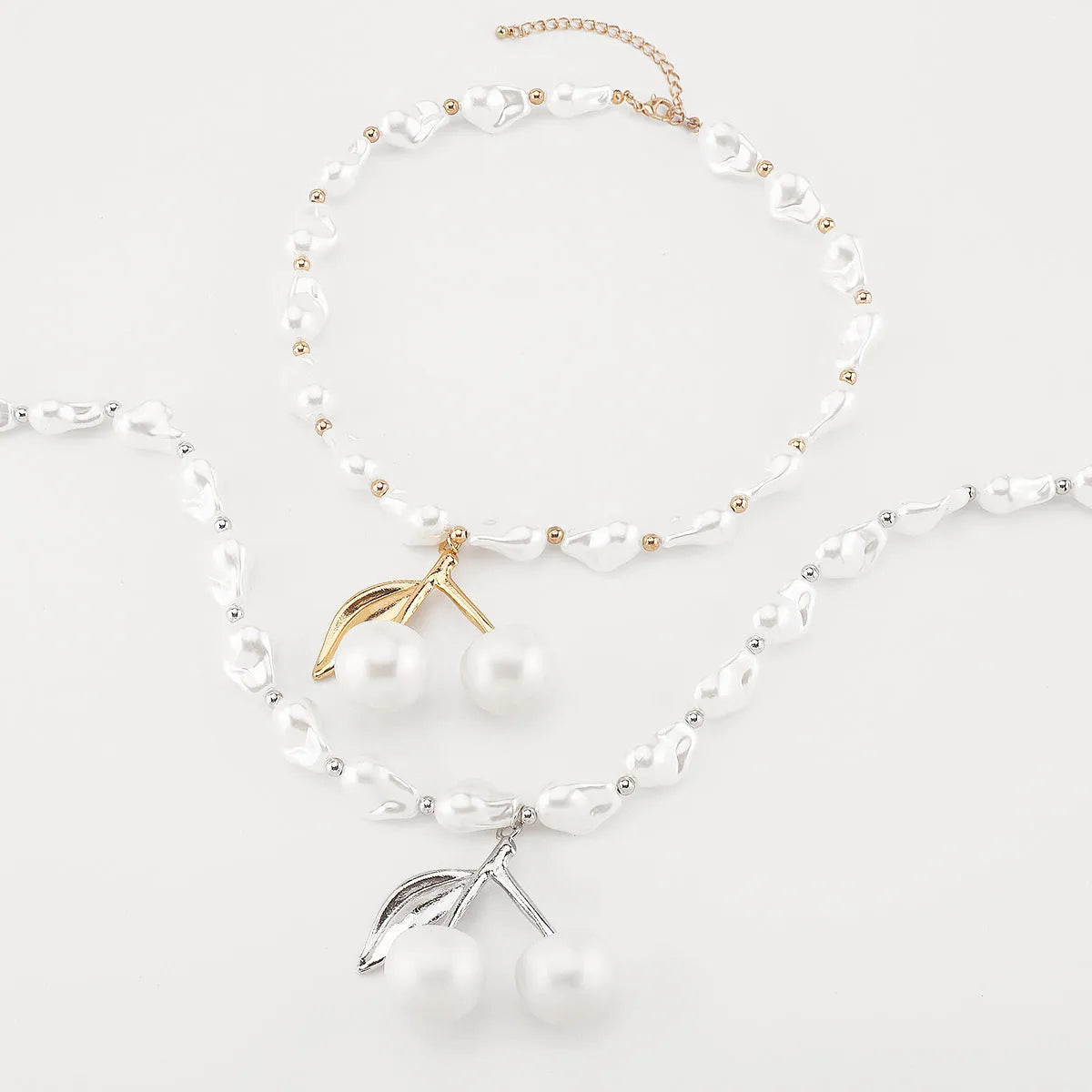 Gold coloured alloy cherry fruit pendant on an adjustable imitation pearl necklace for women.