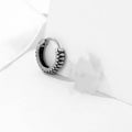 Silver geometric twist earrings with circular elements on white background