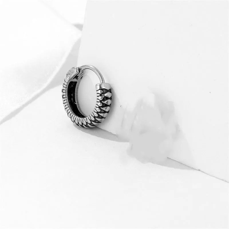 Silver geometric twist earrings with circular elements on white background
