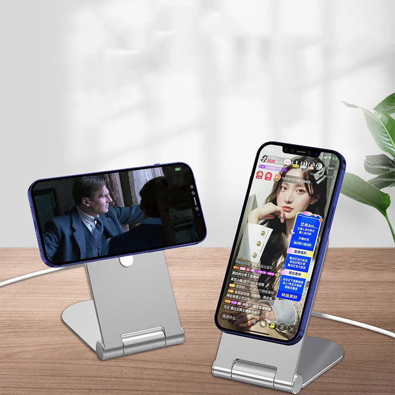 Silver vertical adjustable magnetic phone bracket on a desk, holding an iPhone 12.