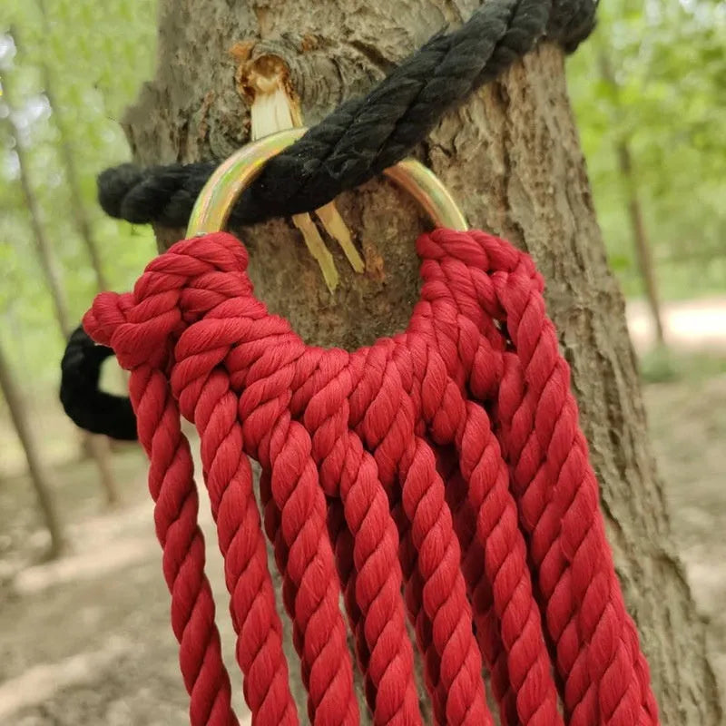 Bold style outdoor nylon rope mesh hammock hung between two trees.
