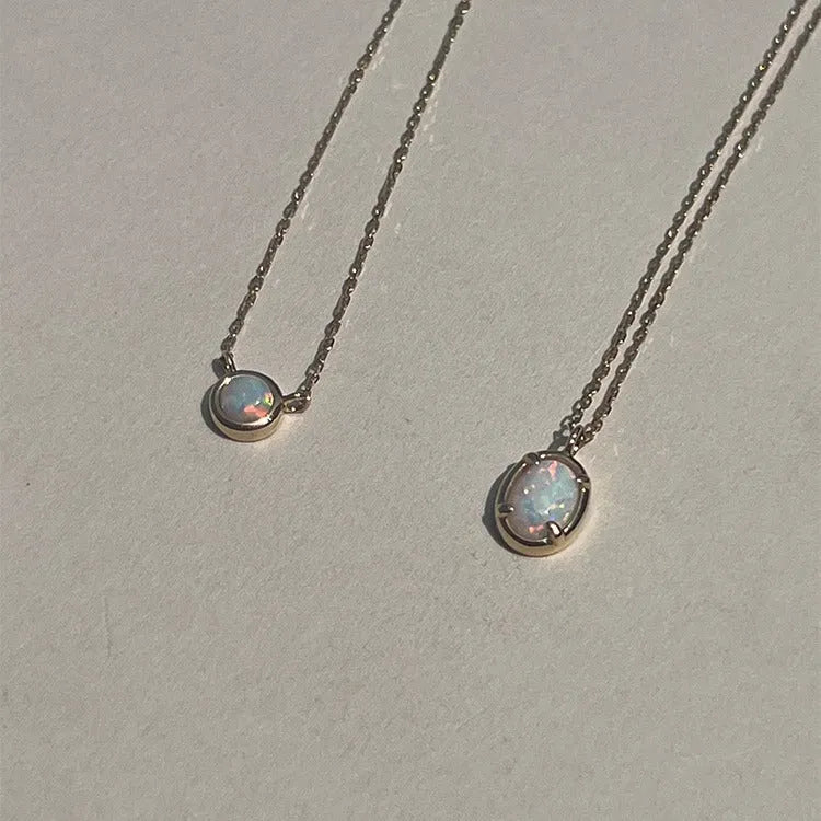 Oval geometric pendant necklace with jelly opal stone in silver plating, shown in golden and white gold colour options.