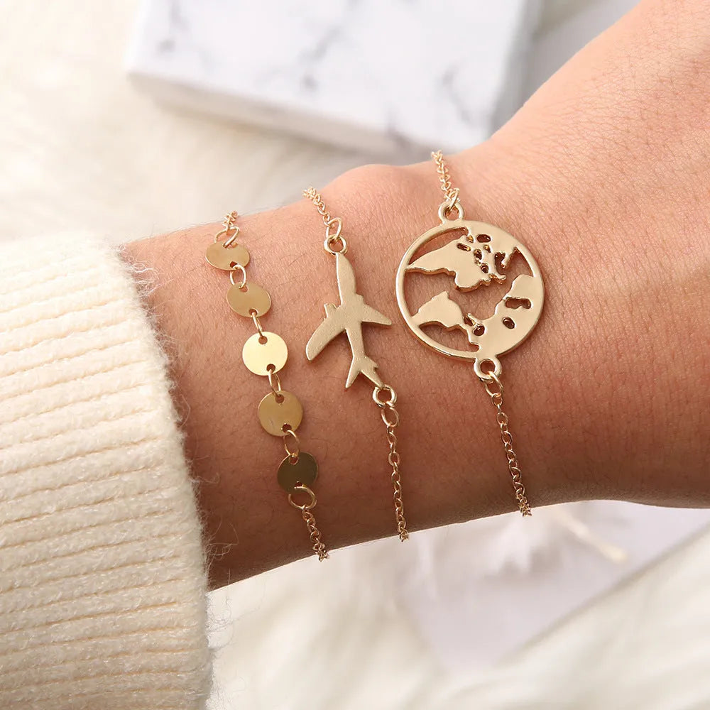 Three matching women's charm bracelets with heart-shaped aviation map designs in electroplated alloy