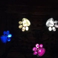 Four black bear paw print solar garden lights with solar panel pole for outdoor path decoration