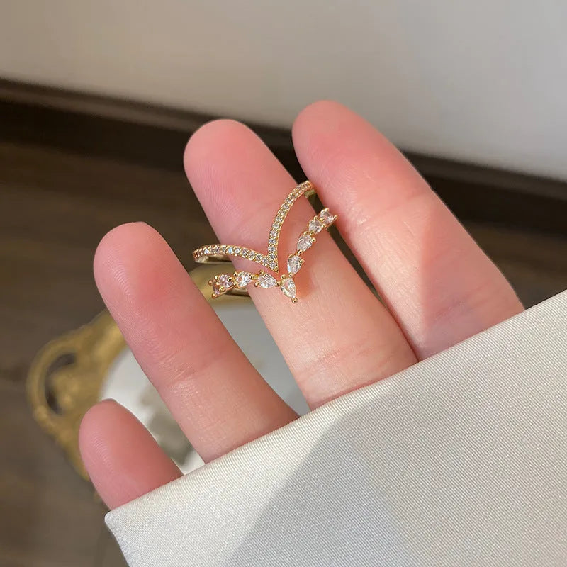 Gold plated copper heart shaped ring with full diamond detailing on white background
