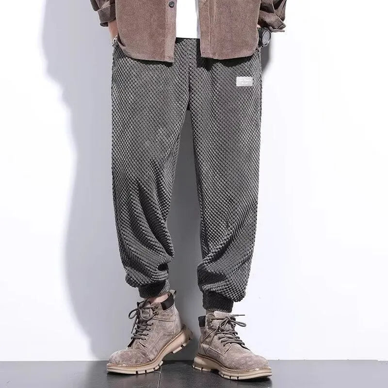 Men's grey ankle-tied straight leg sweatpants laid flat, showing casual sports design.