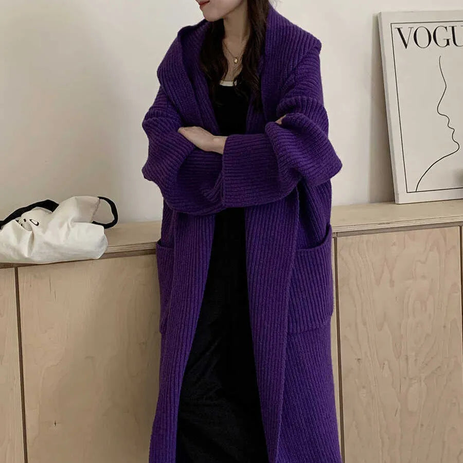 Loose grey hooded cardigan coat with raglan sleeves shown on a hanger.