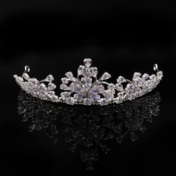 Three piece bridal jewellery set with gold leaf crown necklace and earrings on white background