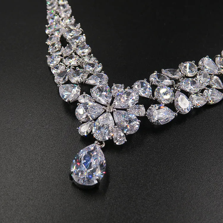 Three piece bridal jewellery set with gold leaf crown necklace and earrings on white background