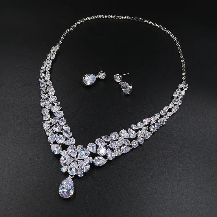 Three piece bridal jewellery set with gold leaf crown necklace and earrings on white background
