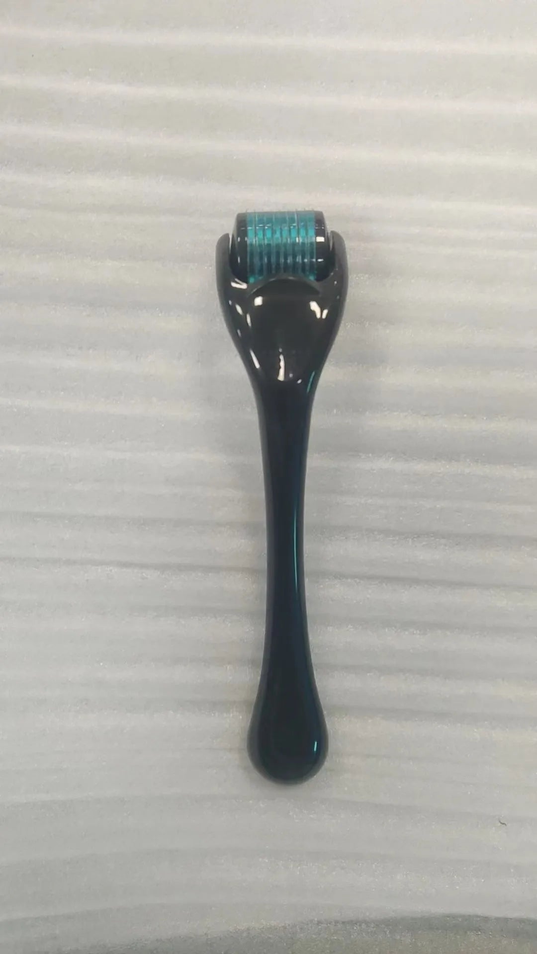Black handle microneedle roller with purple wheel showing 540 needles, next to white and blue handle options.