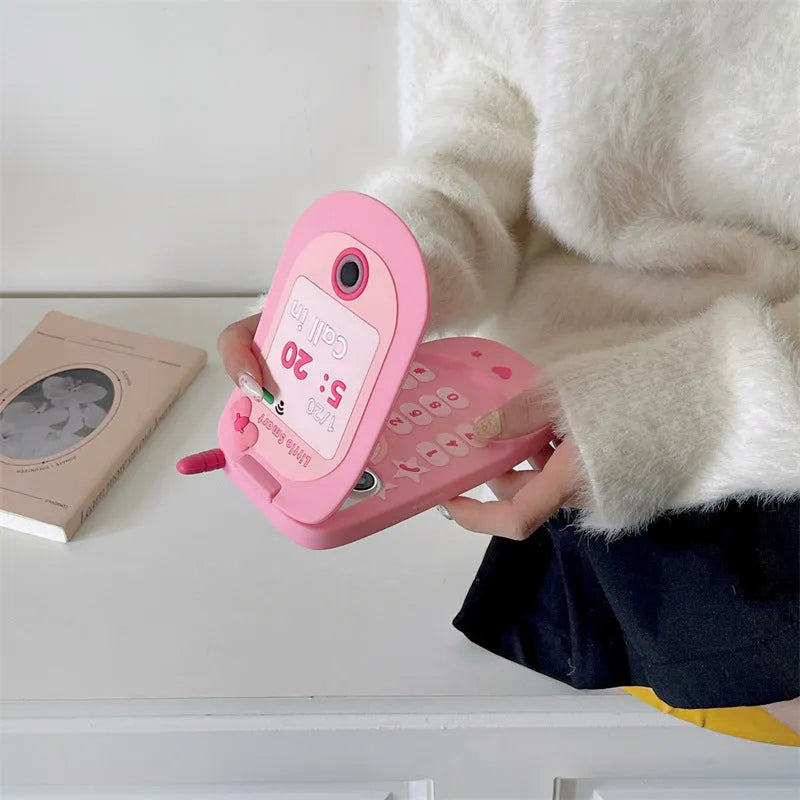 Light pink silicone flip phone case with built-in mirror for iPhone, showing cute cartoon design